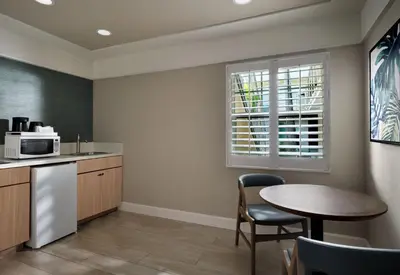 a kitchen with a table and a microwave at Diamond Head Inn in San Diego