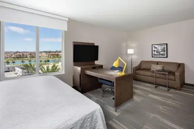 a hotel room with a bed and a desk with a computer at Hampton Inn & Suites San Diego Airport Liberty Station in San Diego