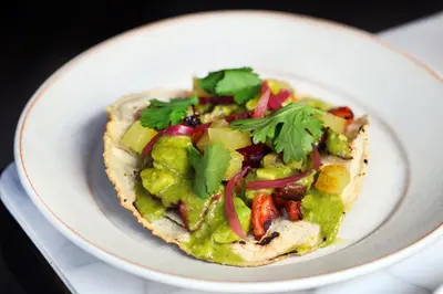 a white plate with a taco with guacamole at Alma San Diego Downtown, a Tribute Portfolio Hotel in San Diego