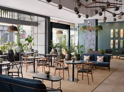 a restaurant with tables and chairs and plants at Alma San Diego Downtown, a Tribute Portfolio Hotel in San Diego