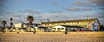 a group of houses on the beach next to a building at The Beach Cottages in San Diego