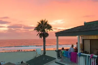 a house on the beach with a palm tree at The Beach Cottages in San Diego