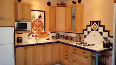 a kitchen with wooden cabinets and a white refrigerator at Kokopelli's Hideaway in Julian