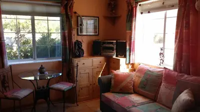 a living room with a couch and a table and windows at Kokopelli's Hideaway in Julian