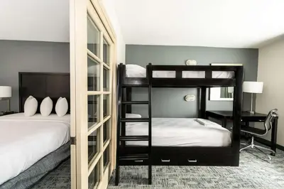 a bedroom with two bunk beds and a desk at Best Western Inn & Suites San Diego Zoo -SeaWorld Area in San Diego