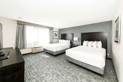 a hotel room with two beds and a desk at Best Western Inn & Suites San Diego Zoo -SeaWorld Area in San Diego