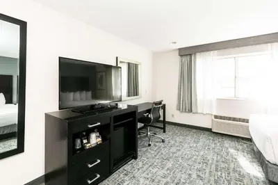 a hotel room with a desk and a bed and a television at Best Western Inn & Suites San Diego Zoo -SeaWorld Area in San Diego
