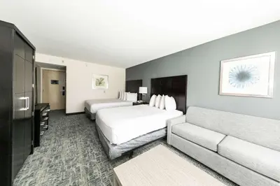 a hotel room with two beds and a couch at Best Western Inn & Suites San Diego Zoo -SeaWorld Area in San Diego