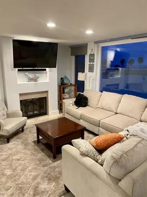 a living room with two couches and a fireplace at 125-Fun In The Sun Penthouse in San Diego