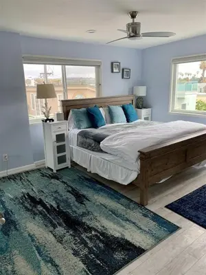 a bedroom with a large bed with blue walls at 120-Oceanfront Penthouse 5 in San Diego