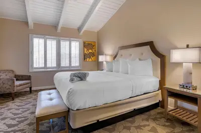 a bedroom with a large white bed and a chair at Best Western PLUS Island Palms Hotel & Marina in San Diego