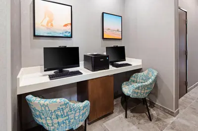 a room with a desk with a computer and two chairs at SpringHill Suites by Marriott Escondido Downtown in Escondido