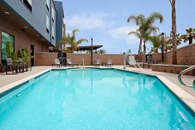 a swimming pool at a hotel with palm trees at SpringHill Suites by Marriott Escondido Downtown in Escondido