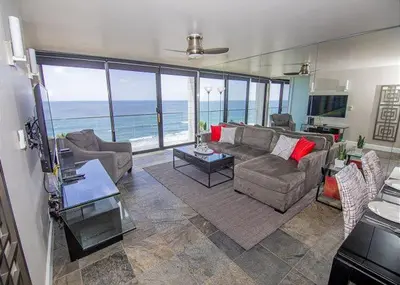 a living room with a view of the ocean at Capri Beach Accommodations at Capri By The Sea in San Diego