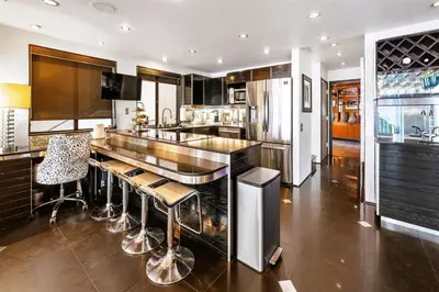 a kitchen with a bar with stools in it at 105-Sleekretreat in San Diego