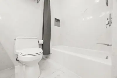 a white bathroom with a toilet and a bath tub at 103-Luxury3 in San Diego