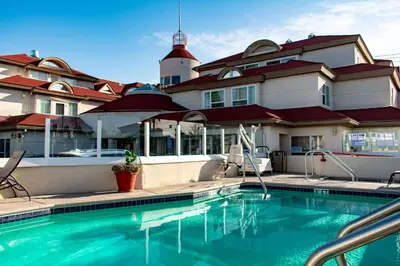 a house with a swimming pool in front of a building at Best Western Plus Suites Hotel Coronado Island in San Diego