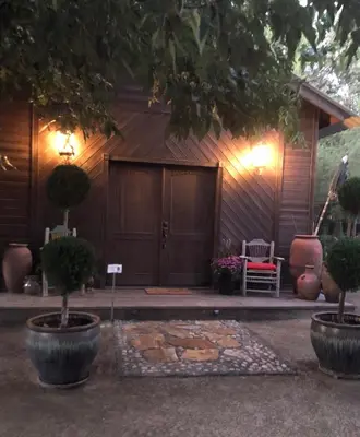 a front door of a house with two potted trees at Wine Country Private Working Sheep Farm; Rustic Elegance in Temecula