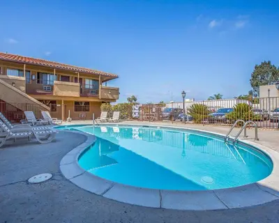 a swimming pool at a resort with chairs and a building at Rodeway Inn Santee San Diego East in Santee