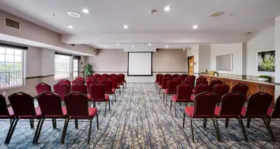 a conference room with red chairs and a whiteboard at Ayres Suites Mission Viejo - Lake Forest in Mission Viejo