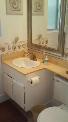 a bathroom with a sink and a mirror and a toilet at 25 Steps to the Beach in Newport Beach