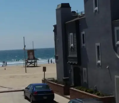 a car parked next to a beach with a building at 25 Steps to the Beach in Newport Beach
