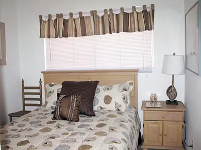 a bedroom with a bed with a window and a table at 25 Steps to the Beach in Newport Beach