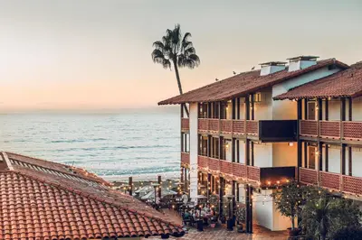 a hotel with a palm tree in front of the ocean at La Jolla Shores Hotel in San Diego