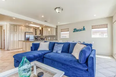 a living room with a blue couch and a kitchen at Ocean Beach Cliffs Sanctuary Oceanfront in San Diego