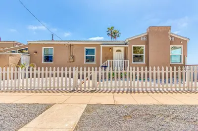 a white picket fence in front of a house at Ocean Beach Cliffs Sanctuary Oceanfront in San Diego