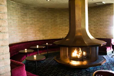 a fireplace in a room with tables and chairs at Borrego Springs Resort in Borrego Springs