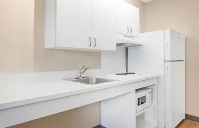 a white kitchen with a sink and a microwave at Extended Stay America Suites - San Diego - Carlsbad Village by the Sea in Carlsbad