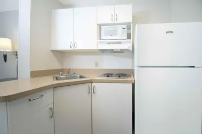 a kitchen with white cabinets and a white refrigerator at Extended Stay America Suites - San Diego - Mission Valley - Stadium in San Diego