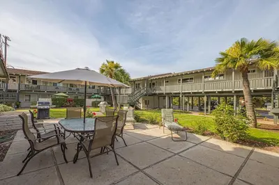 a patio with a table with chairs and an umbrella at Heart of the Village in Carlsbad