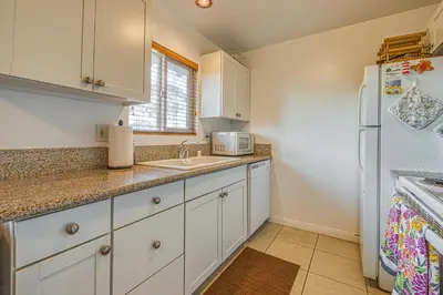a kitchen with white cabinets and a white refrigerator at Heart of the Village in Carlsbad
