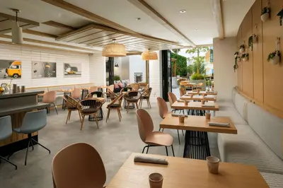 a restaurant with wooden tables and chairs and a cafeteria at The Monsaraz San Diego, Tapestry Collection By Hilton in San Diego