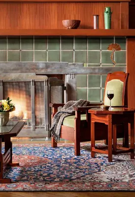 a living room with a fireplace and a table and chair at The Lodge at Torrey Pines in San Diego
