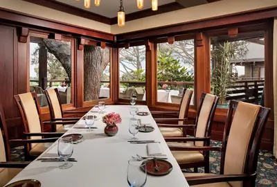 a dining room with a table with glasses and flowers at The Lodge at Torrey Pines in San Diego