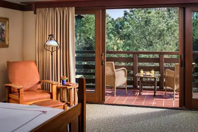 a living room with a balcony with a sliding glass door at The Lodge at Torrey Pines in San Diego