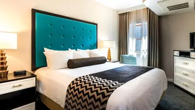 a hotel room with a bed with a large headboard at WorldMark San Diego - Balboa Park in San Diego