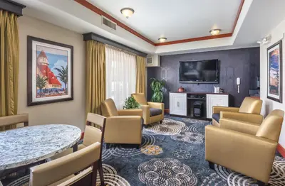 a waiting room with a table and chairs and a television at WorldMark San Diego - Balboa Park in San Diego