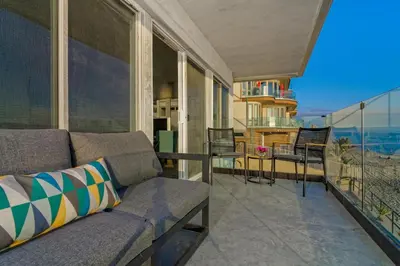 a living room with a couch and a balcony at Ocean Villas Beach Front in Carlsbad