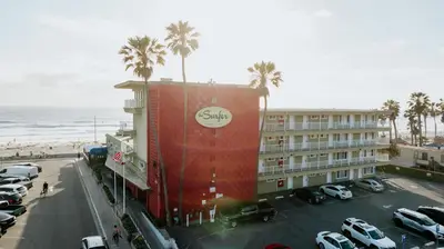 a building with a sign on it next to a parking lot at Surfer Beach Hotel in San Diego