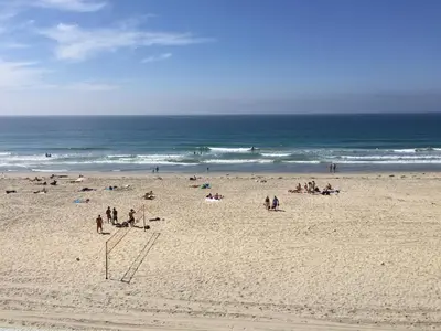 a group of people on a beach near the ocean at Surfer Beach Hotel in San Diego