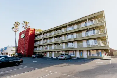 a large building with cars parked in a parking lot at Surfer Beach Hotel in San Diego