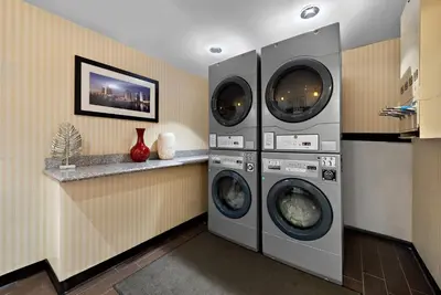a laundry room with three washing machines and a counter at Comfort Inn Gaslamp Convention Center in San Diego