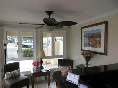 a living room with a couch and a ceiling fan at Ocean Beach Hotel in San Diego