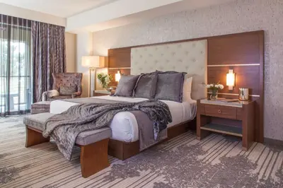 a hotel room with a large bed and a chair at Legacy Resort Hotel & Spa in San Diego