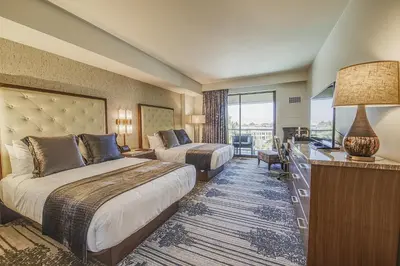 a hotel room with two beds and a desk at Legacy Resort Hotel & Spa in San Diego