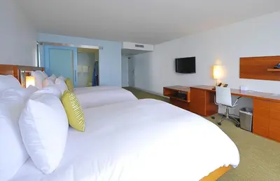a hotel room with a large white bed and a desk at Tower 23 Hotel in San Diego